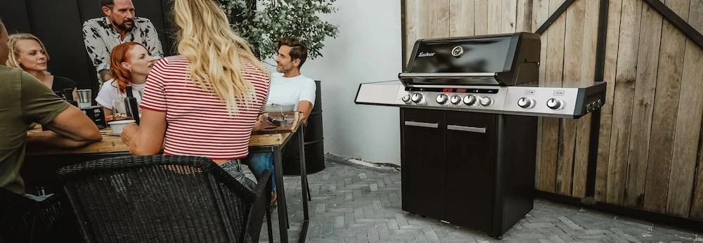 Vier Menschen auf einer Terrasse bei einem Grillfest